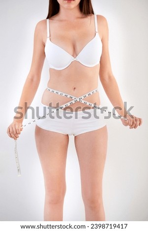 Waist, body and woman with tape measure in underwear for weight loss, health and wellness isolated on a white studio background. Hands, stomach and abdomen of girl on diet for beauty, care or figure