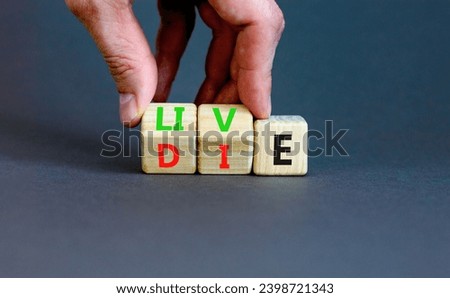 Live or die symbol. Concept word Live or Die on wooden cubes. Beautiful grey table grey background. Businessman hand. Business lifestyle and live or die concept. Copy space.