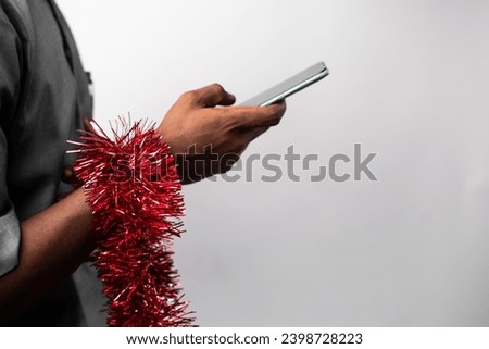 A man using his phone against a plain backdrop