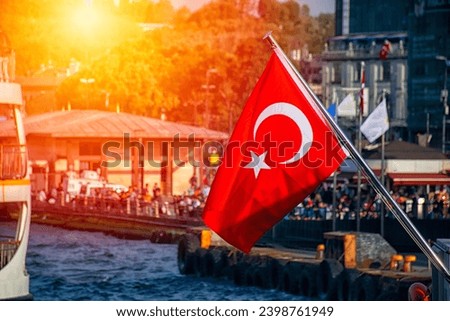 Turkish flag at sunset and blurred city view in the background. Royalty-Free Stock Photo #2398761949