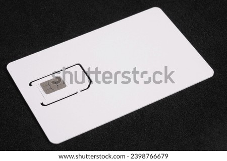 White SIM card isolated on black background. Plastic SIM card for mobile phone, close up