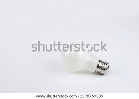 Light bulb casting reflections on a bright surface. Dynamic play of light enhances the visual appeal, creating a captivating image with a blend of innovation and luminosity. Royalty-Free Stock Photo #2398769339