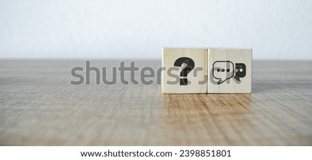 Q and A concept. Q and A symbols on wooden cube blocks on a grey background.