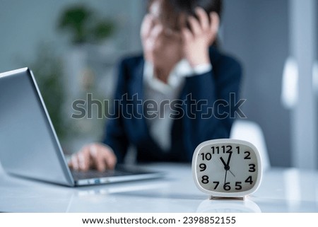 woman holding her head in the office Royalty-Free Stock Photo #2398852155