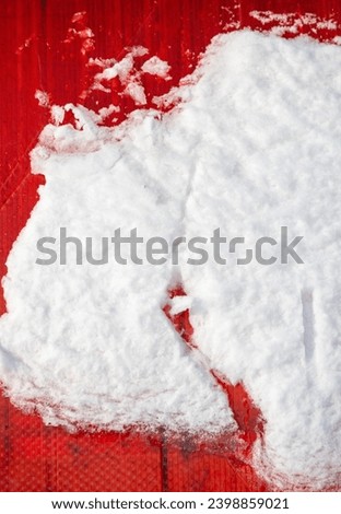 White snow on a red roof wall