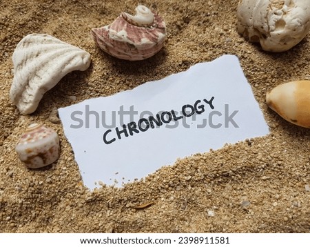 Chronology writing on beach sand background.