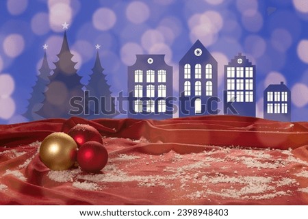 christmas card scene with silhouettes of paper cut houses and christmas trees, bokeh lights and christmas decoration