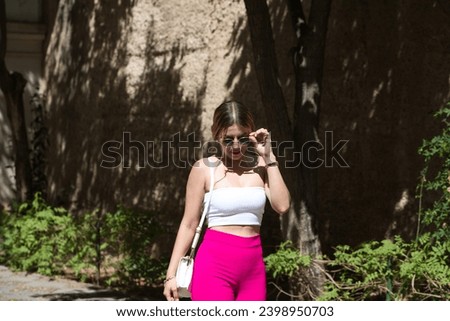 Young latin woman, blonde and pretty with sunglasses is on holiday and strolling around the city. The woman is South American and is travelling around Europe on holiday. Travel and holiday concept