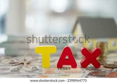 inheritance tax, estate tax concept. Tax word on wood block with money and house and property transfer documents.