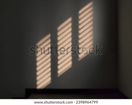 The afternoon sunlight streams through the window onto the cement wall.  Sunlight surface.  Passage through sunny stairs.  Sunlight shines into the building.  Space of light between floors and walls.