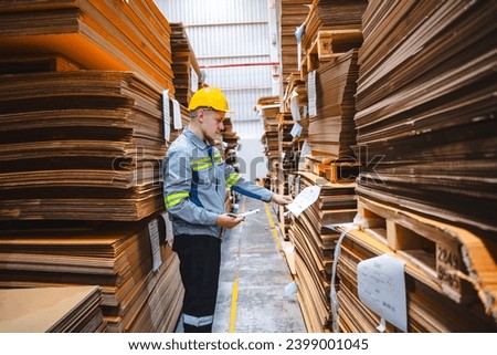 Professional worker team in safety uniform, supervisor inspector in packaging stock order at cardboard factory warehouse, piles of stacking paper manufacture, recycling industrial production Royalty-Free Stock Photo #2399001045