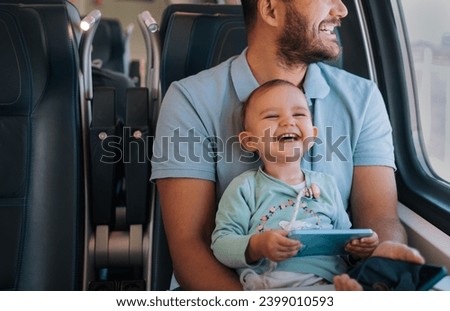 
Adorable baby is watching a cartoon and laughing hard while riding a train