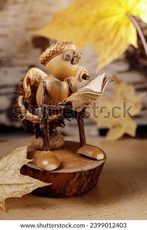 Autumn scene with a little man made of acorns reading a book on the toilet. The picture is suitable for a book cover or an advertising poster for advertising the autumn book fair.