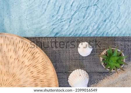 Exotic dish seen from above on a wooden floor above a pool with shells. Ambiance vacation in summer.	