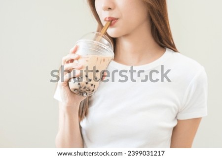 Beverage and food concept, Happy asian young woman hand holding plastic cup, glass of drink bubble, pearl milk tea with straw, cute girl drinking ice cold tea with tapioca boba ball popular in Taiwan. Royalty-Free Stock Photo #2399031217