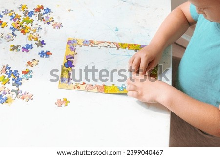 A boy collects a picture puzzle, educational games for children, close-up