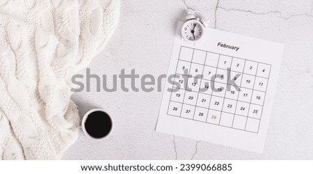 Leap year concept, calendar, alarm clock and coffee on light top view web banner Royalty-Free Stock Photo #2399066885