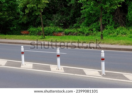 Street with lanes delimited by road separators. Other names are reflective traffic separator, traffic separator barrier, road block traffic barrier.
