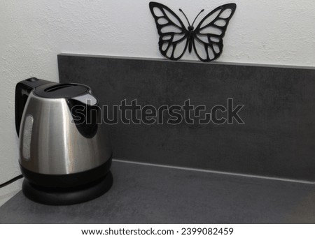 Water kettle standing on a kichen table with a 3d printed butterfly