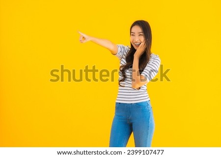 Portrait beautiful young asian woman smile happy with action on yellow isolated background