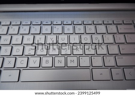 The white laptop keyboard with black letters has a QWERTY layout.