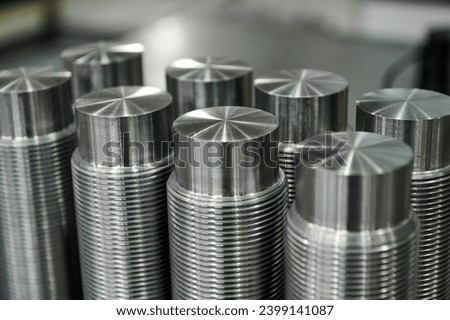 Metal pins with screw thread on table in light storehouse