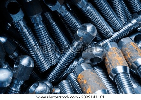 Large crank pins with nuts pile in warehouse macro view Royalty-Free Stock Photo #2399141101