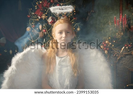 A little girl dressed as an angel  stands in a beautiful Christmas setting. Merry Christmas and Happy New Year! Vintage style. Copy space.