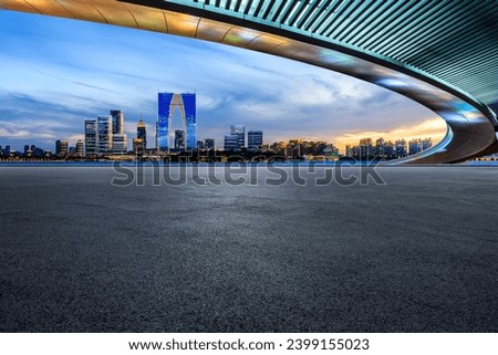 Asphalt road square and bridge with city skyline at night in Suzhou, China.