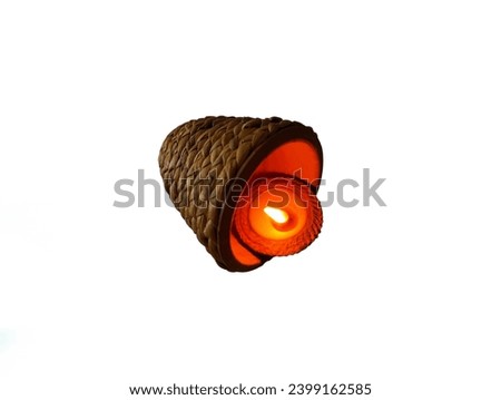 The picture shows a fire in an orange clay pot with a flame in the center and a large orange censer woven with bamboo.