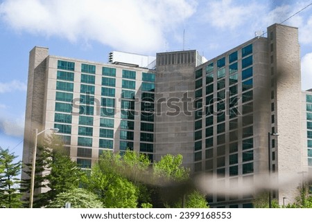 Modern Glass and Stone Building amidst Greenery in Urban Setting, Bloomington