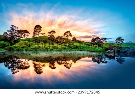 The lovely image depicts nature's tranquil beauty, with a hill, lake, trees, and an enthralling sunset in the background