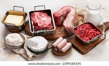 Saturated fats on tables. Raw meat, sausages, cheese, butter. Bad food concept.  Royalty-Free Stock Photo #2399184195