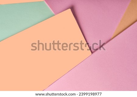 Multi colored abstract paper of pastel green,pink and peach fuzz colors , with geometric shape, flat lay