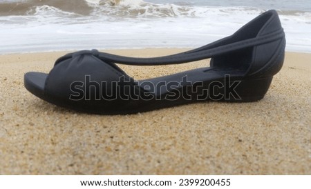 this is a picture of black shoes with a beach background
