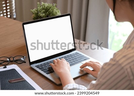 Woman using laptop with blank copy space screen for your advertisement. on the table in office.