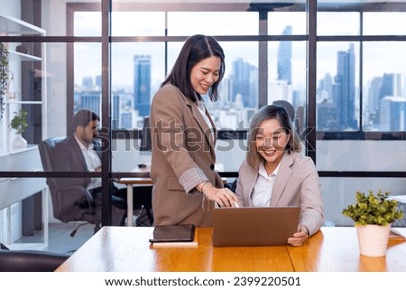 Businesswoman team leader is guiding young member to business success by showing information for goal achievement for startup and creativity project Royalty-Free Stock Photo #2399220501