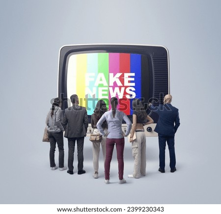 Group of people watching fake news on TV, they are standing in front of an old television and looking at the screen Royalty-Free Stock Photo #2399230343