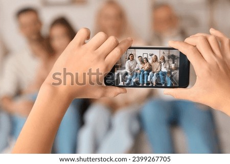 Little boy with mobile phone taking picture of his big family at home, closeup