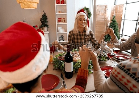 Mature woman praying before Christmas dinner with her family at home in evening