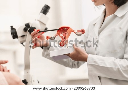 Medical examination in a gynecologist's chair, the doctor shows and explains the genital organs of women. the doctor shows a silicone demonstration model of the female reproductive system (uterus, vag Royalty-Free Stock Photo #2399268903