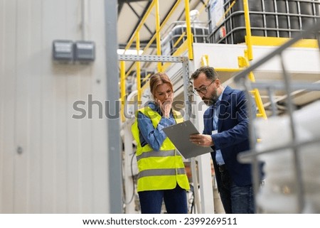 Supervisor, manager scolding employee in modern industry factory. Worker making mistake. Production manger is angry, dissatisfied for worker's poor quality work, safety viaolations. Gender harassment Royalty-Free Stock Photo #2399269511