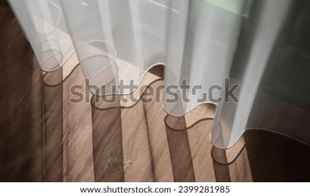 Sunlight falling on wooden floor and creating shadow from curtains background. Interior design sewing curtains concept Royalty-Free Stock Photo #2399281985