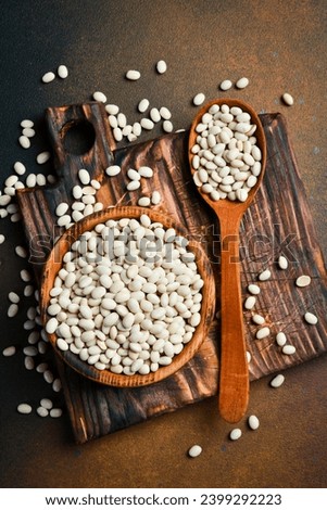 Raw Organic White Beans in a Bowl. Cannellini, Navy, Great Northern or White Kidney Beans. Healthy Diet Concept. Top view, Copy Space, Space for Text.