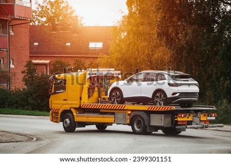 Tow truck with a broken car on a road. Tow truck transporting car on the highway. Car service transportation concept. Roadside Rescue. Royalty-Free Stock Photo #2399301151