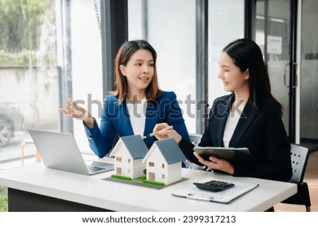 Real estate broker agent presenting and consult to customer to decision making sign insurance form agreement, home model, concerning mortgage loan offer in office

