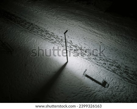 Beautiful landscape with bench and snow at night. Outside travel background. Cold weather. Aerial view of winter park. Drone view. Stock photo.