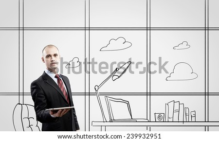 Young confident businessman standing in drawn office