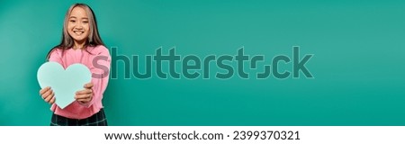 14 february banner, cheerful asian woman holding heart shaped carton on turquoise background