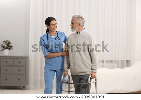 Smiling nurse talking with elderly patient in hospital